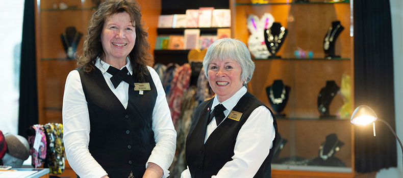 Two female Volunteers standing at Showcase - our gift shop