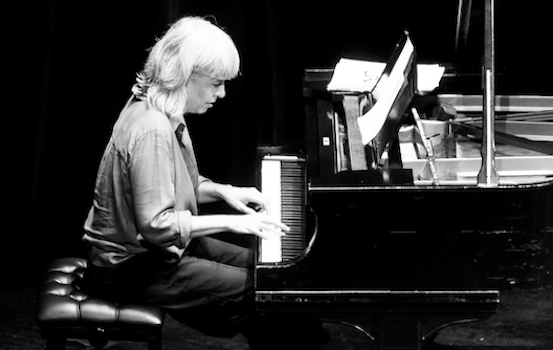 Black and white image of Tania Gill playing a piano.